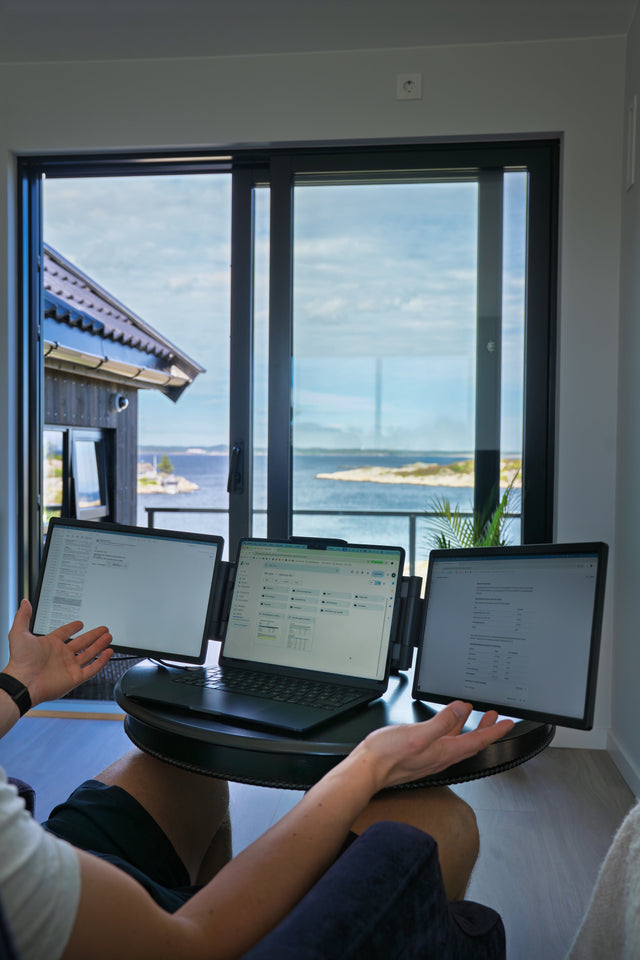 Nærbilde av arbeid på laptop med to ekstra skjermer
