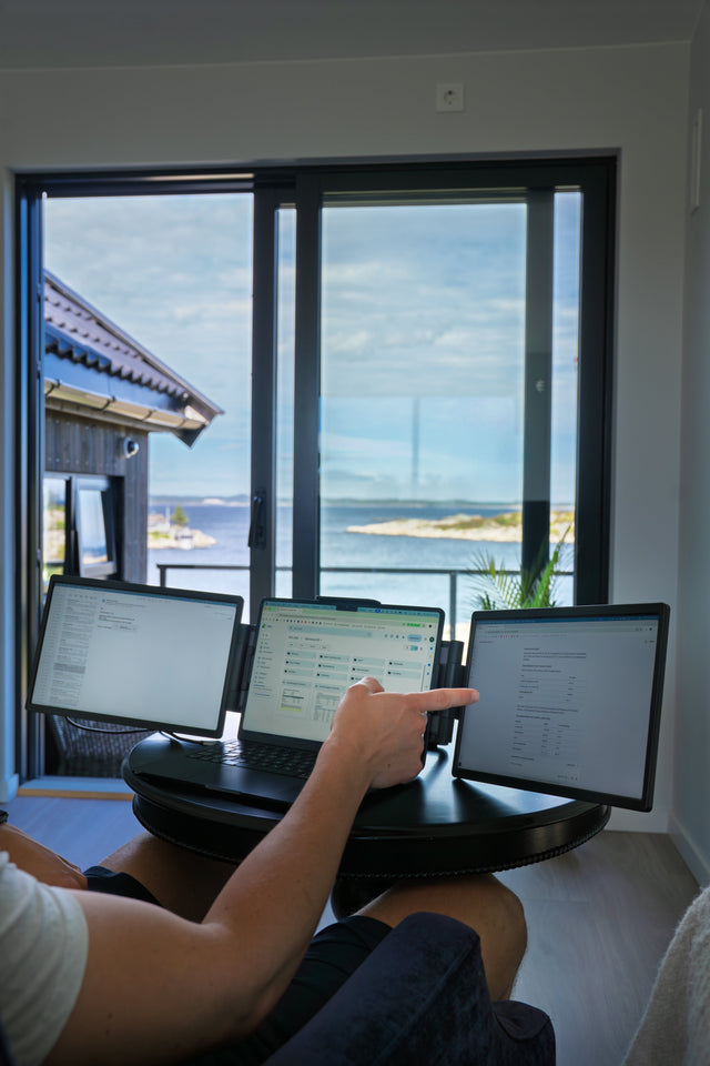 Hands on a laptop keyboard with a portable screen on each side