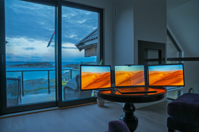 Three screens set up indoors in front of a large window