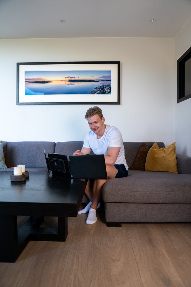 Person working from a sofa with a portable dual screen