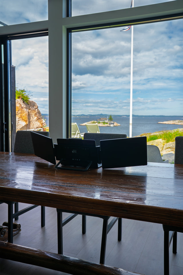 Portable dual monitor set up on a wooden table with a view